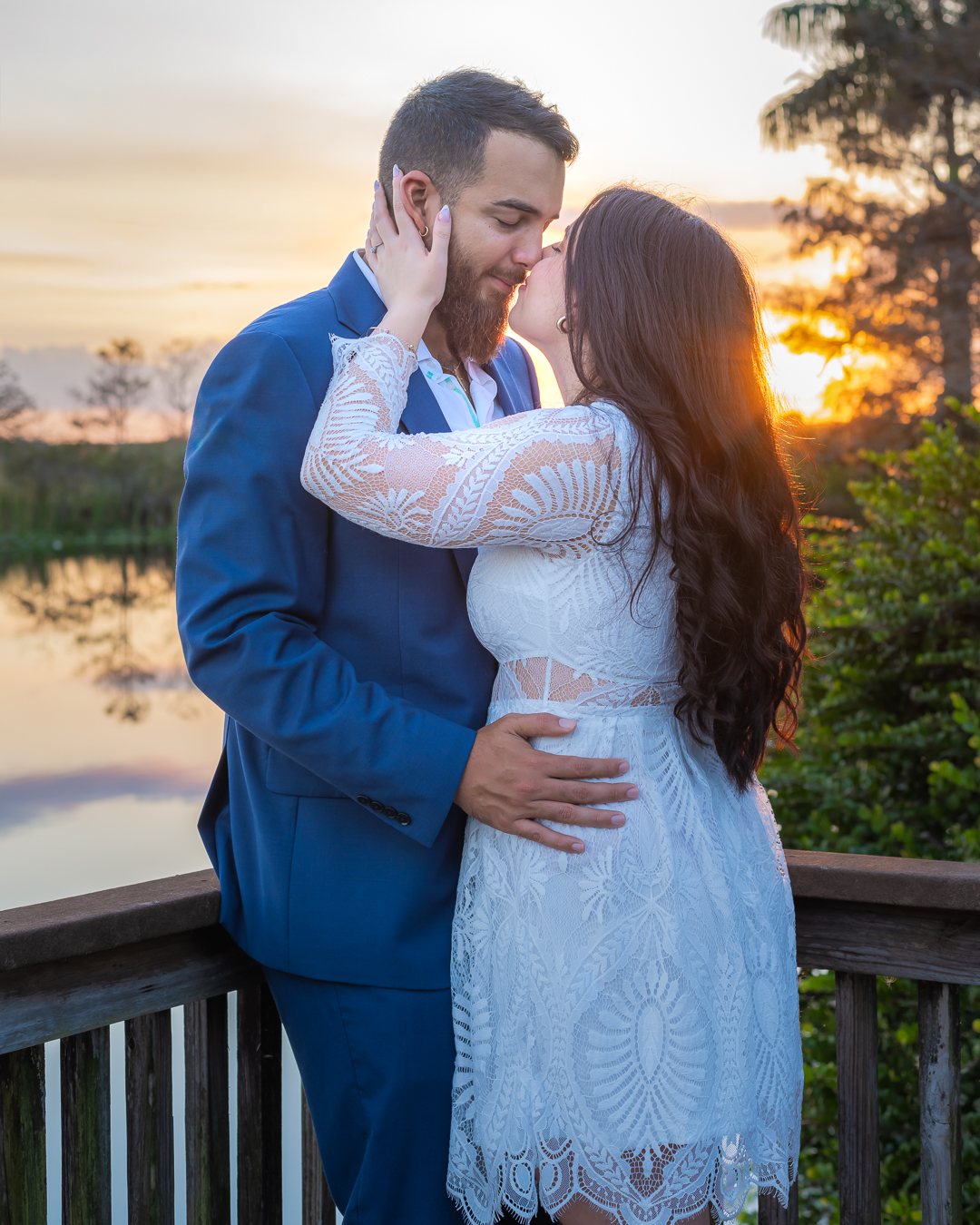 Pareja besándose al atardecer durante su sesión de compromiso